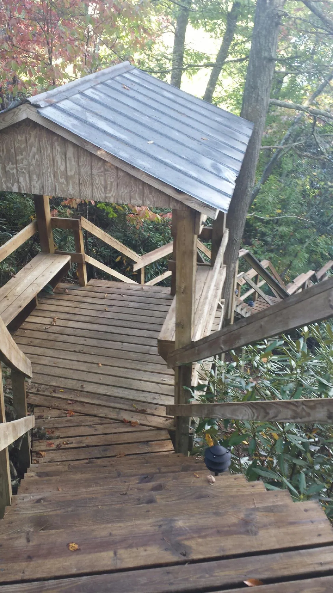 Metal roofed shelter over wooden steps on a wooded walkway — Skylight Repair & Installation work by our crew in Solway