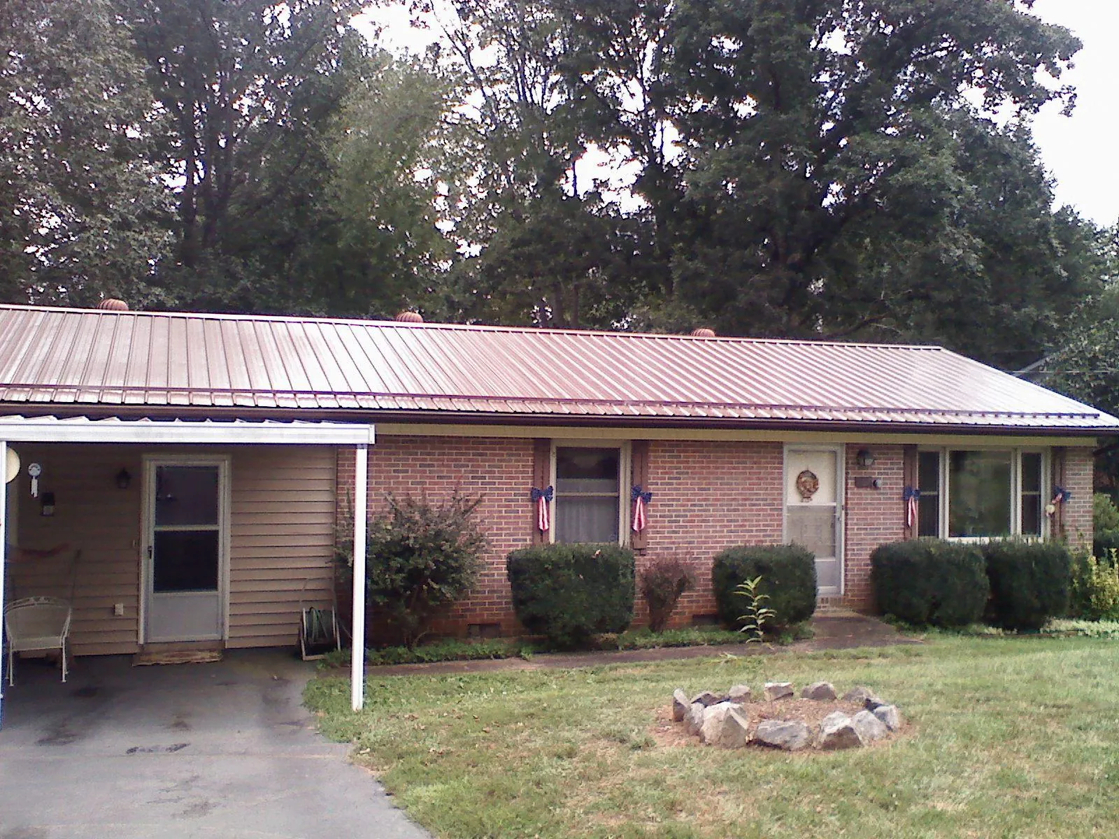 Bronze metal roof and carport on a brick ranch home — Roof Repair work by our crew in Solway